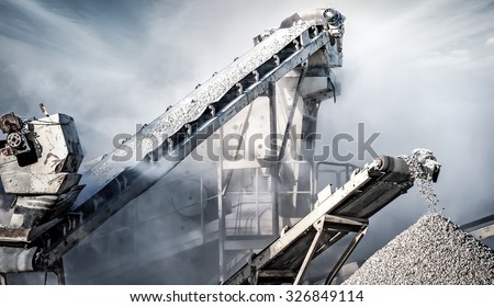 Cement production factory on mining quarry. Conveyor belt of heavy machinery loads stones and gravel