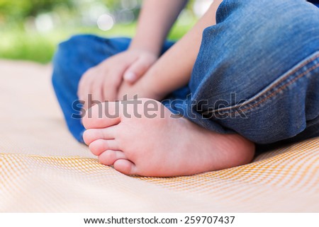 Foot of seated child on picnic or yoga. Selective focus