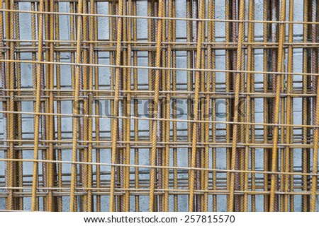 Steel rods used for construction leaned against wall
