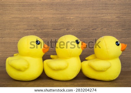 Three yellow fabric ducks waiting in a line, queue