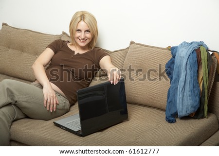 pregnant woman siting on a couch with laptop
