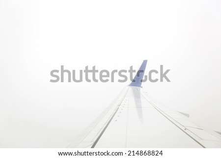 Airplane wing out of window in fog