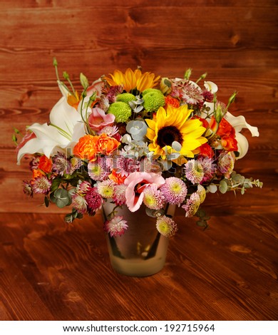 floral bouquet with lily, sunflower, chrysanthemum, eustoma (lisianthus) astrantsiya, eucalyptus, shrub rose on wooden board