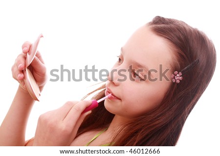 pretty little girl making makeup with mirror and lip gloss