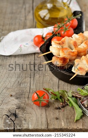 Chicken skewers with vegetables on wooden table