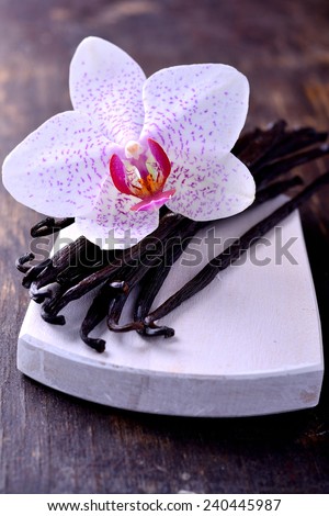 Vanilla Pods and Flower over Wooden Background. Vanilla Pod Stick