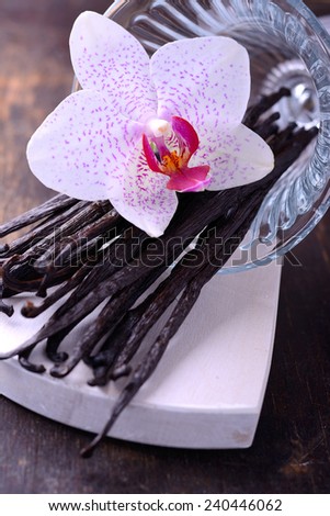 Vanilla Pods and Flower over Wooden Background. Vanilla Pod Stick