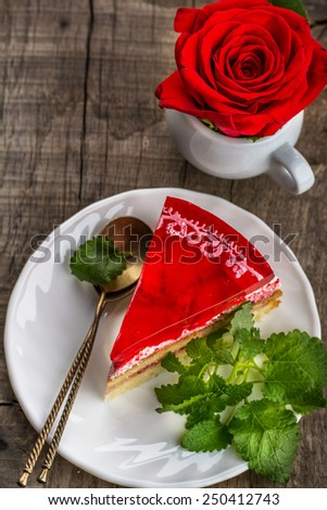 bright cake with strawberries and strawberry jelly on the wooden background with bright roses. Romantic concept servings. Serve in kafe.Vyborochny focus