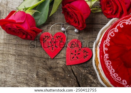 bright cake with strawberries and strawberry jelly on the wooden background with bright roses. Romantic concept servings. Serve in kafe.Vyborochny focus