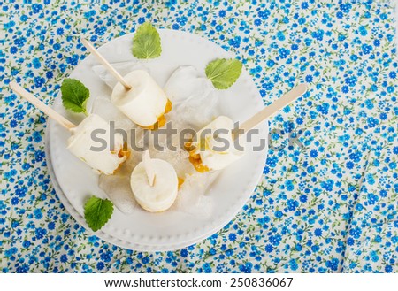 Homemade ice cream with berries cloudberries. Several ice lolly on a plate filled with ice. selective Focus