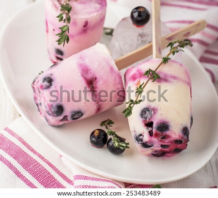 Homemade ice cream lolly with berries blackberry. Several ice lolly on a plate filled with ice. selective Focus