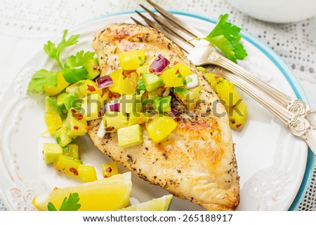 Grilled chicken breast with fresh salsa frompineapple and avocado with red sweet onion , soft selective  focus