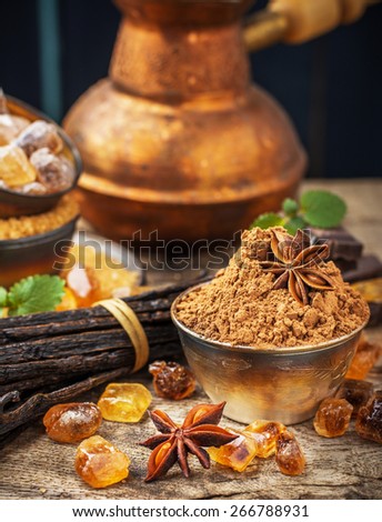 Golden caramel brown sugar crystals, vanilla pods, cocoa powder in a metal cup on vintage wooden background. selective Focus