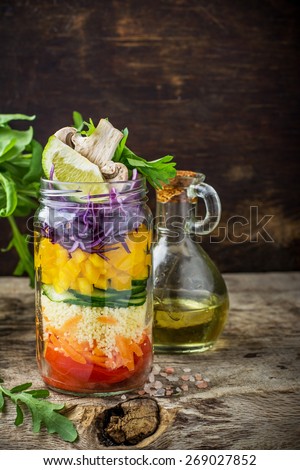 Bright rainbow salad  of tomatoes, carrots, pepper, red cabbage, arugula and mushrooms with butter and sea salt on a pink background vegetables and herbs. Trends in healthy eating. Selective focus.