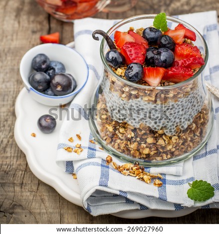 Chia seed pudding made with blueberries,  strawberries, vanilla, oatmeal for breakfast and mint on a wooden background. Selective focus. The concept of good nutrition