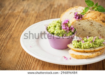 Green hot sauce made with fresh garlic arrows with nuts and butter in portion piala on the wooden background with the sprigs of marjoram. selective Focus