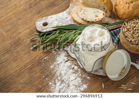 Oat flour, grain oats, oat bread on wooden background with home lyanm textiles. selective Focus