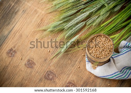 Ears of barley and wheat on the wooden background. selective Focus