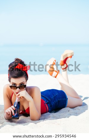 Pin-up on sand with drink