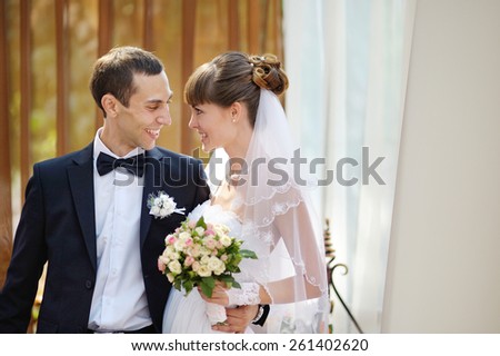 young man and woman, the bride and groom posing on the balcony looking at each other