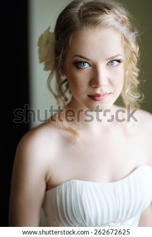 portrait of a beautiful young girl with big blue eyes, blond hair, the bride in her wedding dress
