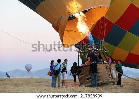 Cappadocia, Turkey -  August, 10 2013 :  Passengers climbing into hot air balloon basket. When the pilot is ready for launch, more heat is directed into the envelope and the balloon lifts off.