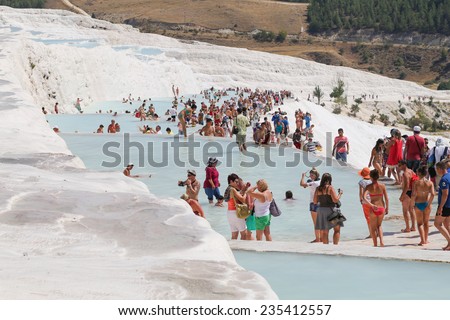 Pamukkale, Turkey - August, 8 2014: Tourists on Pamukkale Travertine pools and terraces. Pamukkale is famous UNESCO world heritage site in Turkey