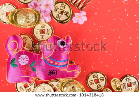 Chinese new year decoration:golden dog statue and gold ingots,translation of calligraphy: 2018 is year of the dog,red stamp: good Fortune for year