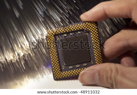 people hand with cpu for a computer on a technology fiber optic background