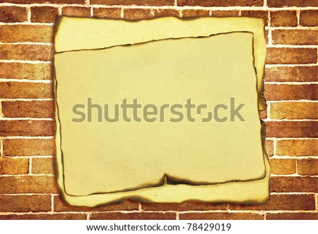 old burnt paper with burnt edges over grunge brick wall background
