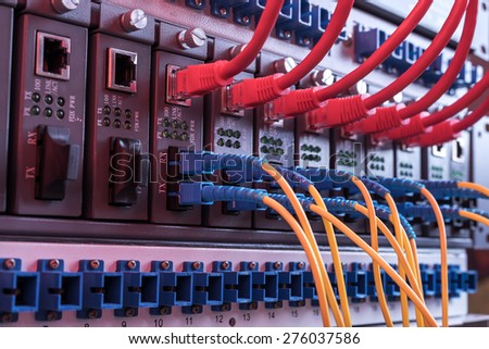 Fiber Optic cables connected to an optic ports and UTP Network cables connected to ethernet ports.