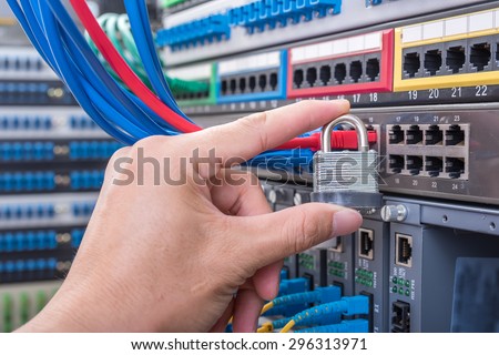 hand holding a security lock with Network switch and ethernet cables