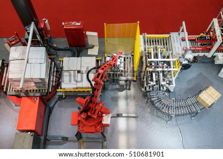 Robotic arm at production line with automatic conveyor belt, industry track.