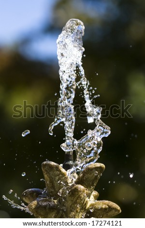 Macro color photograph of water shooting up from a fountain.