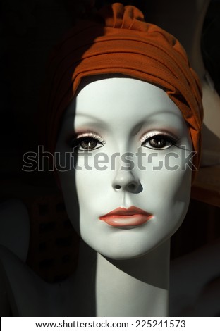 Noble face of a female mannequin with a brown headgear