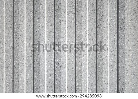 Close-up of a industrial wall covering made of gray plastic profile with a vertical striped pattern and bubble-shaped surface texture
