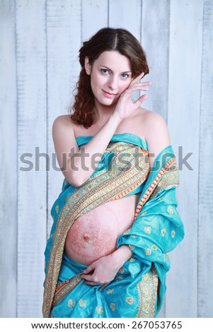pregnant woman in sari with henna tattoos on her belly