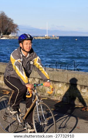 asian male cycle athlete practice beside the lake