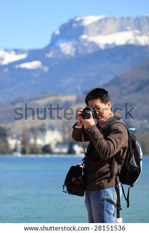 photographer taking picture in front of snow mountain