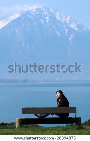 asian girl sitting in front of lake in the beautiful nature