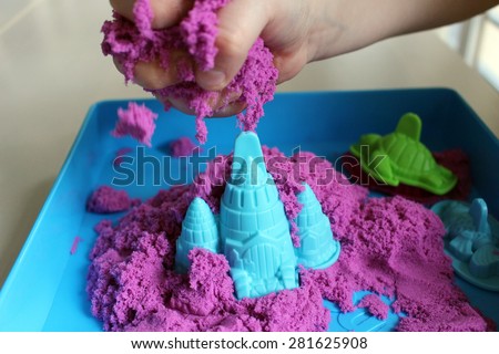 Fun kinetic sand. Child building sandcastle