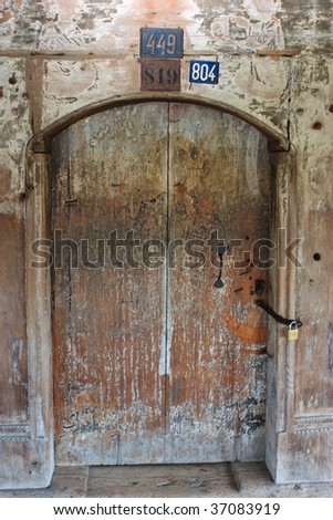 An old wooden door which originally was painted, but the painting faded away in time. The entrance door in the wooden church in Salistea de Sus, Maramures, Romania
