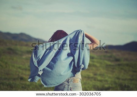 Girls playing in the meadow. Portrait woman in vintage style. Woman wearing denim jacket