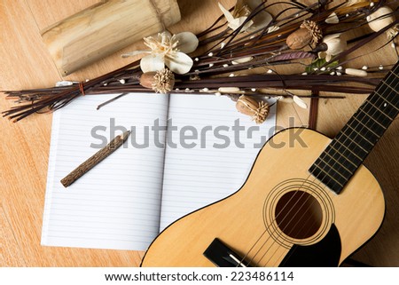 Notebook and pencil on guitar,Writing music