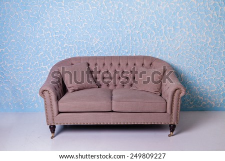 Antique armchair sofa couch in vintage room on blue textured wall