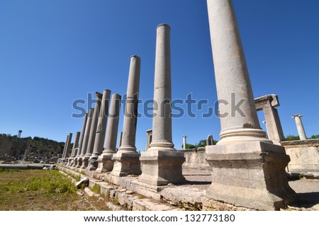 line of well preserved ancient greek columns against a clear blue sky