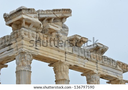 Entablature of an ancient greek temple, with the frieze, column capitals  and architrave in evidence.