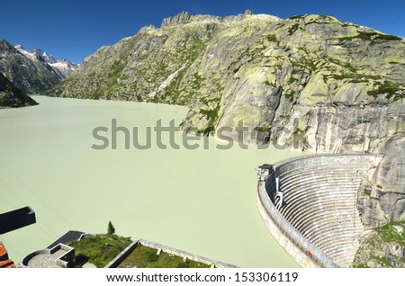 View of the Grimsel  lake (grimselsee), the hydro-electric dam, and the Brunberg (right) in the Bernese alps, on a sunny summer day