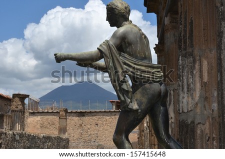 bronze statue of the roman god Apollo at the ancient town of Pompei, with mount Vesuvius behind