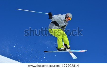 VERBIER, SWITZERLAND - FEBRUARY 24: Freestyle skier performing a tele-heli stunt jump with crossed skis: February 24, 2014 in Verbier, Switzerland